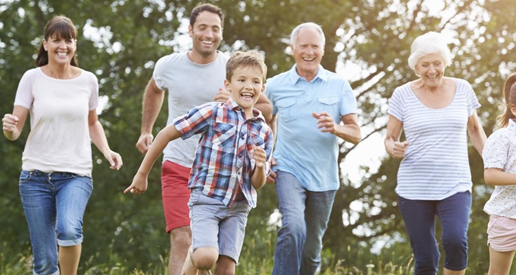Familia multigeneracional corriendo juntos por el campo