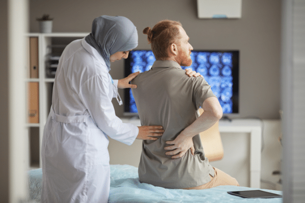 Doctor assessing patient with back pain